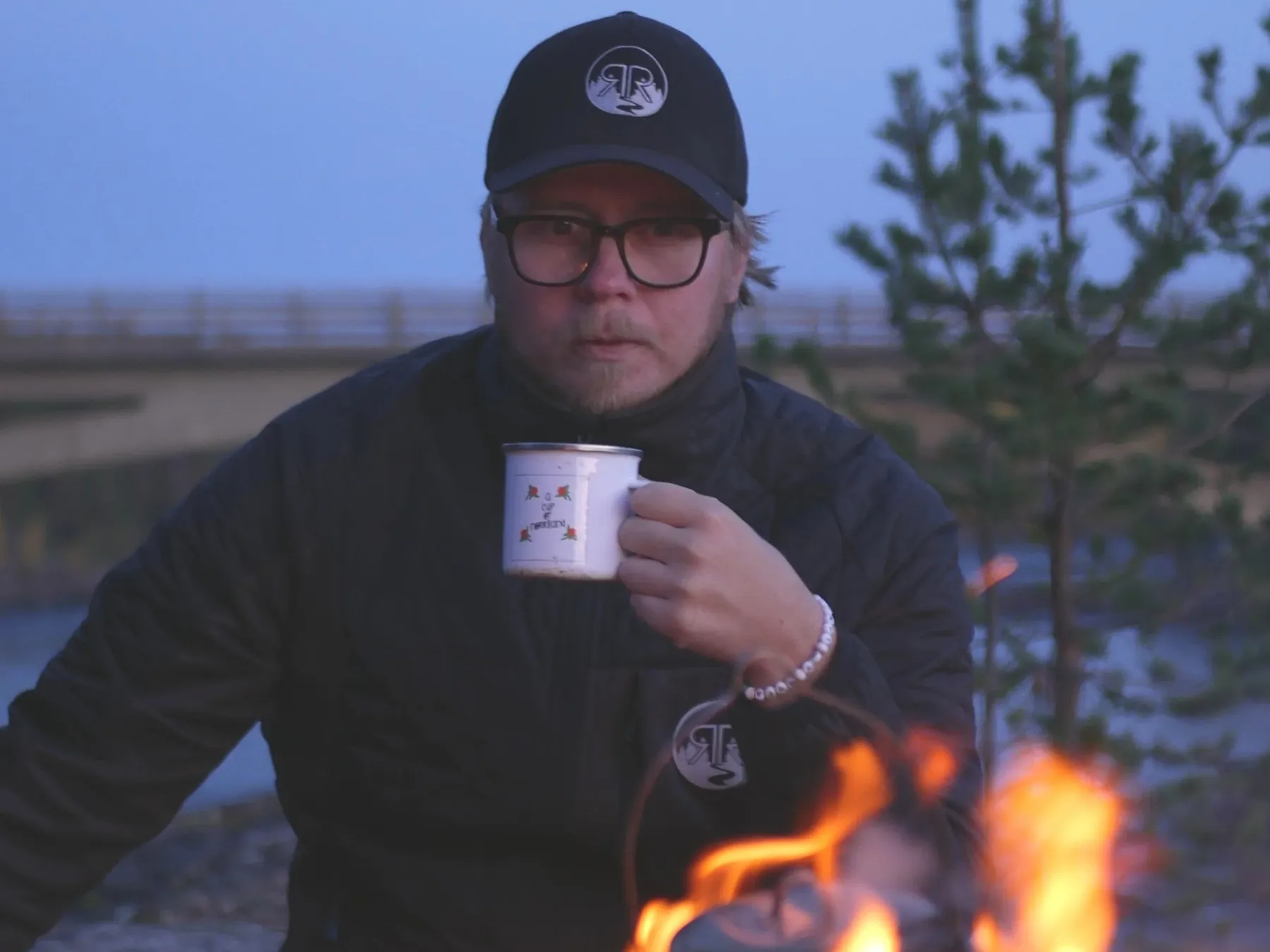 Pontus Johansson med en kaffekopp vid en lägereld